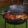 A cast iron skillet is placed on a grill over glowing coals. Náhled obrázku produktu