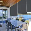 An outdoor patio with a table and chairs, overlooking a body of water. Voir les images du produit