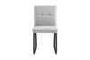 A single light gray dining chair with black metal legs is shown from the front against a white background. Náhled obrázku produktu