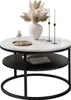 A modern round coffee table with a white marble-look top and a black lower shelf, decorated with a vase of dried flowers, glasses, a carafe, and two candlesticks. Produktbild-Vorschau