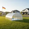 A covered swimming pool in a residential backyard with houses in the background and a German flag. Produktbild-Vorschau