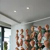 A ceiling with recessed lights and a decorative hanging installation of ceramic vases. Produktbild-Vorschau