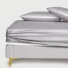 Silbernes Satin-Spannbettlaken und zwei Kissenbezüge auf einem hellgrauen Bettrahmen mit goldenem Bein Produktbild-Vorschau