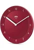 A red Braun wall clock with white hands and numbers against a white background. Náhľad obrázku produktu
