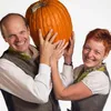 A man and a woman are holding a large pumpkin. Produktbild-Vorschau