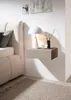 A bedside table with a lamp and decorative items on it, next to a bed. Produktbild-Vorschau
