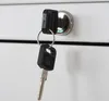 A close-up of a key in a lock on a white surface. Produktbild-Vorschau