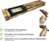 A wooden planter box with a black insert containing mounting hardware and instructions. Produktbild-Vorschau