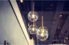 A close-up shot of several glass pendant lights hanging from a ceiling. Anteprima dell’immagine prodotto