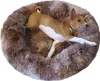 A dog is lying in a round, fluffy brown dog bed. Produktbild-Vorschau