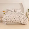 A neatly made bed with floral patterned bedding. Produktbild-Vorschau