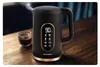 A black electric kettle with a digital display is shown on a wooden table next to a small glass of coffee. Steam is rising from the kettle. Náhled obrázku produktu