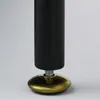 A close-up shot of the bottom of a black furniture leg with an adjustable gold foot. Podgląd zdjęcia produktu