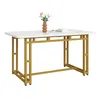 A rectangular dining table with a white marble-effect top and a gold metal frame, set against a white background. A small vase with flowers and two books are placed on the table. Podgląd zdjęcia produktu