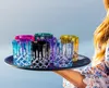 A person holding a tray of colorful glasses. Produktbild-Vorschau