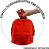 A hand is placing a small red card game into a red backpack. Náhled obrázku produktu