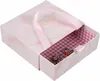 A pink marble patterned jewelry box with a pink ribbon handle is shown with its drawer partially open, revealing a collection of colorful charms and rings inside. The interior of the box is lined with a red and white gingham pattern. Náhled obrázku produktu