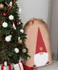 A Christmas tree decorated with ornaments and a large sack with a gnome design next to it. Anteprima dell’immagine prodotto