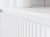 A close-up, angled view of a white fluted cabinet or furniture piece. Náhled obrázku produktu