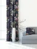 A living room scene with a floral curtain, a sofa with a cushion, and a tall white vase with branches. Produktbild-Vorschau