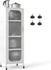 A white kitchen cabinet with glass doors and wheels, shown with kitchenware inside and some feet accessories next to it. Podgląd zdjęcia produktu