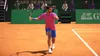 A tennis player in a pink shirt and blue shorts is playing tennis on a clay court. Podgląd zdjęcia produktu