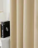 A close-up view of a beige curtain, with a book visible on a white surface to the left. Produktbild-Vorschau