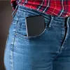 A close-up shot of a person's hip area, showing a black smartphone tucked into the front pocket of blue denim jeans. The person is wearing a red and black plaid shirt. Produktbild-Vorschau