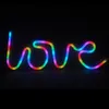 A neon LED sign spelling out the word "LOVE" in rainbow colors against a black background. Anteprima dell’immagine prodotto