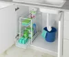 Under-sink cabinet with a pull-out organizer filled with cleaning supplies. Anteprima dell’immagine prodotto