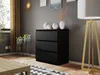 A modern black dresser with three drawers is placed in a living room setting, next to a tall floor lamp and a window with golden curtains. Náhled obrázku produktu