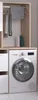A laundry room setup with a washing machine and a cabinet. Produktbild-Vorschau