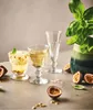 Three glasses of drinks with passion fruit and basil, along with passion fruit halves, on a table. Podgląd zdjęcia produktu