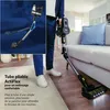 A person is using a cordless stick vacuum cleaner in a living room, demonstrating its ability to clean under furniture. Náhled obrázku produktu