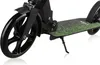 A close-up shot of a black kick scooter with a green grass-like pattern on the deck, resting on a white background. Náhľad obrázku produktu