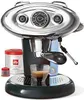 A black and silver Illy X7.1 Espressomaschine Hyperespresso Automatik is shown with a cup of espresso, a can of Illy coffee, and two small red caps. Podgląd zdjęcia produktu