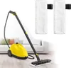A yellow steam cleaner with a mop attachment sits on a wooden floor in front of a white couch. Two white microfiber mop pads are shown separately in the upper right corner. Produktbild-Vorschau