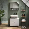 A modern bathroom with a green tiled wall, a white sink and vanity, and a ladder shelf. Voir les images du produit