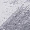 A close-up view of a textured rug with a geometric pattern in shades of white and gray. Produktbild-Vorschau