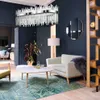 A modern living room with a large chandelier, armchair, coffee table, and rug. Produktbild-Vorschau