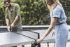 Two people setting up a table tennis table outdoors. Produktbild-Vorschau
