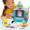 A young girl is playing with a Play-Doh kitchen set, creating cakes and pastries. Produktbild-Vorschau