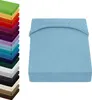A stack of colorful fitted sheets is shown on the left, and a single light blue fitted sheet is displayed prominently on the right. Produktbild-Vorschau