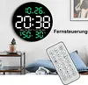 A digital wall clock with a remote control in a living room setting. Produktbild-Vorschau