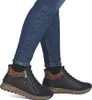 A person wearing blue jeans and black boots with leopard print accents. Náhľad obrázku produktu