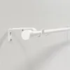 A white curtain rod mounted on a white wall. Voir les images du produit