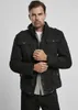 A man wearing a black jacket and jeans against a light gray background. Produktbild-Vorschau
