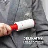 A person is using a lint roller on a gray plaid jacket. Produktbild-Vorschau