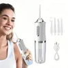 A woman is smiling and holding a portable water flosser, with the product and its accessories displayed separately. Náhľad obrázku produktu