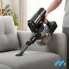 A person is using a cordless vacuum cleaner on a gray sofa. Podgląd zdjęcia produktu